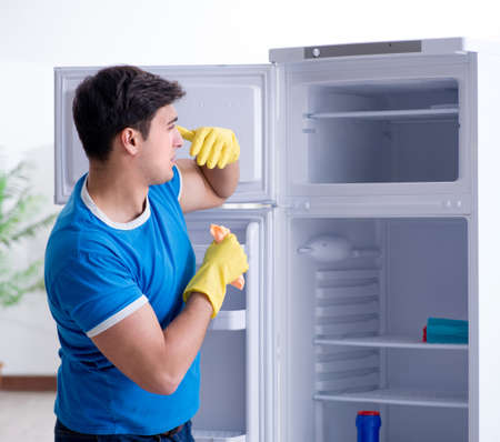 Man cleaning fridge in hygiene conceptの写真素材