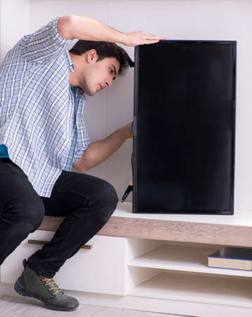 Man repairing broken tv at homeの写真素材