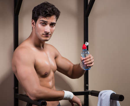 Thirsty man drinking water in sports gym
