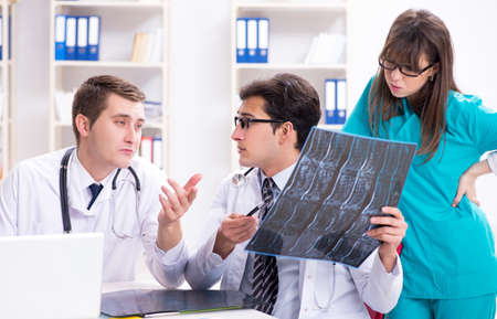 Three doctors discussing scan results of x-ray image