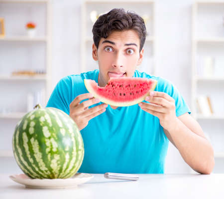 Man eating watermelon at homeの写真素材