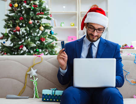 Businessman working at home during christmasの写真素材