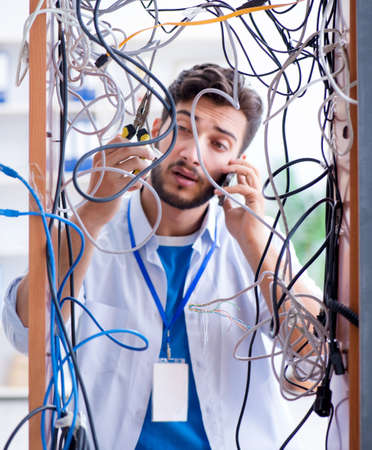 Electrician trying to untangle wires in repair conceptの写真素材