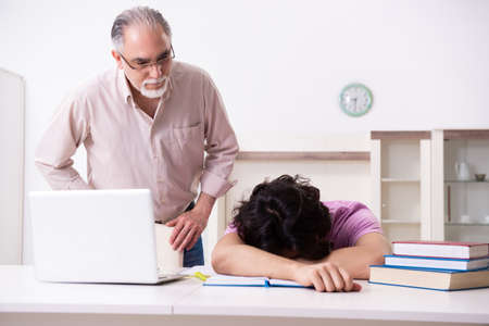 Old father helping his son in exam preparationの写真素材