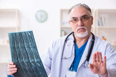 Old male doctor working in the clinic