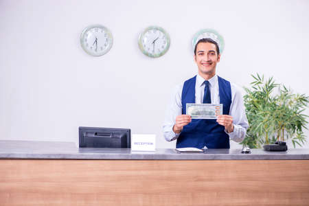 Young man receptionist at the hotel counterの写真素材