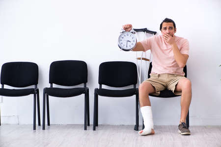 Young injured man waiting for his turn in hospital hall
