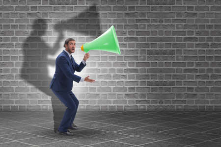 Businessman shouting through large loudspeaker