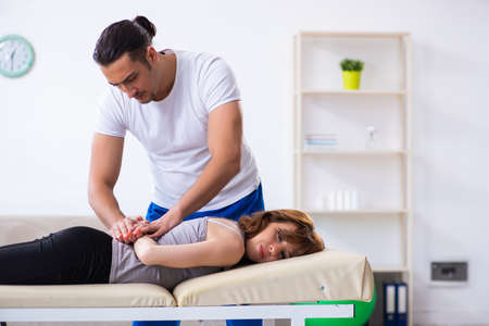 Young woman visiting male doctor physiotherapistの写真素材