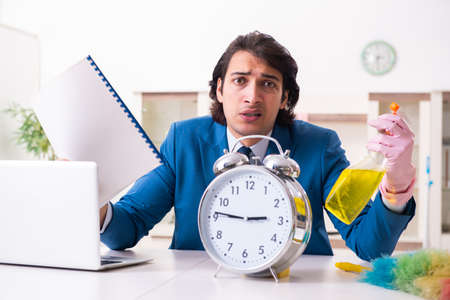Young businessman cleaning the houseの写真素材