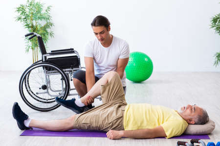 Old injured man doing exercises indoorsの写真素材