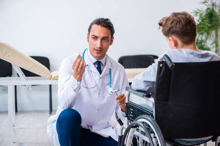 Young male doctor pediatrist and boy in wheel-chairの写真素材