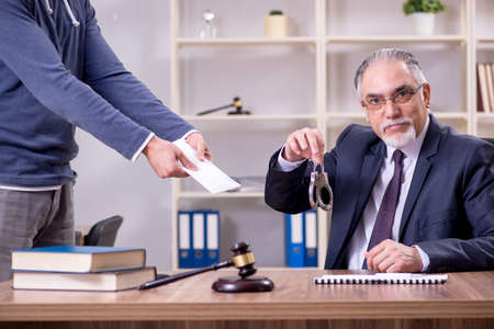 Old male lawyer in corruption concept