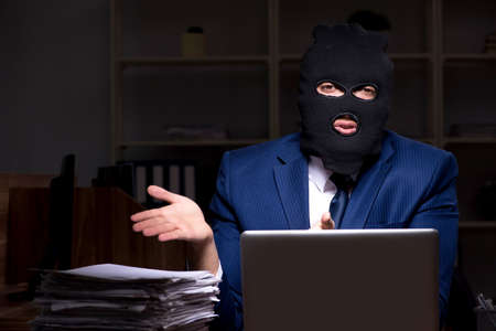 Male employee stealing information in the office night time