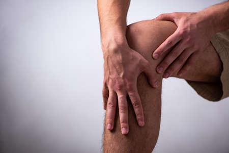 Young man suffering from leg pain