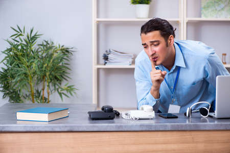 Young male travel agent working in the office