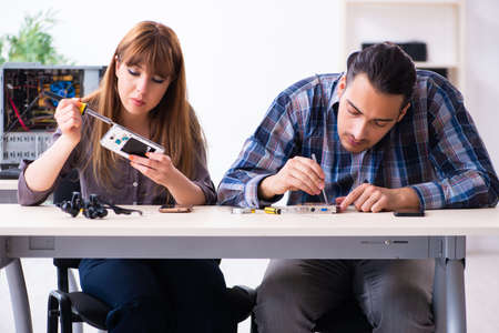 Two technicians working at computer warranty centerの写真素材