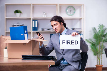 Young male employee being fired from his workの写真素材