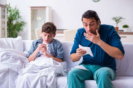 Young father caring for sick sonの写真素材