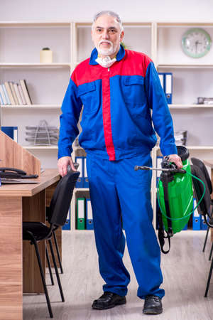 Old professional contractor doing pest control in the officeの写真素材