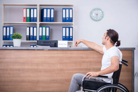 Young man at hospital reception deskの写真素材