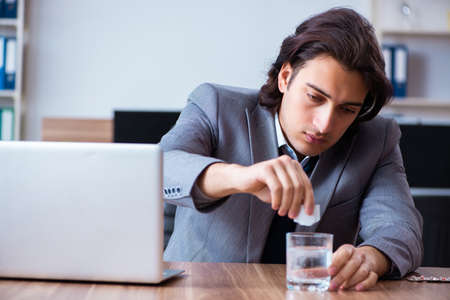 Sick male employee suffering in the officeの写真素材