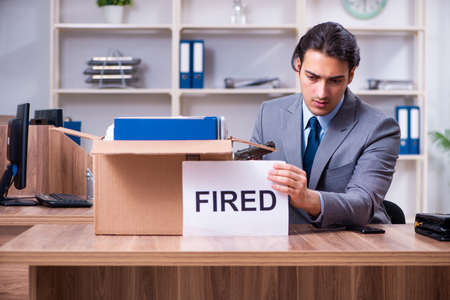 Young male employee being fired from his workの写真素材