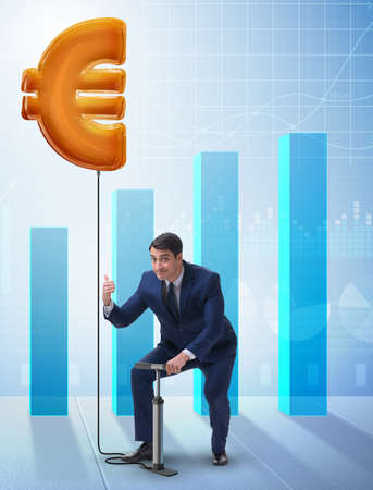 The businessman pumping euro sign in business conceptの写真素材