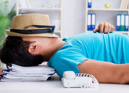 Businessman preparing for vacation in the officeの写真素材