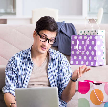 Young man buying clothing online and running blogの写真素材