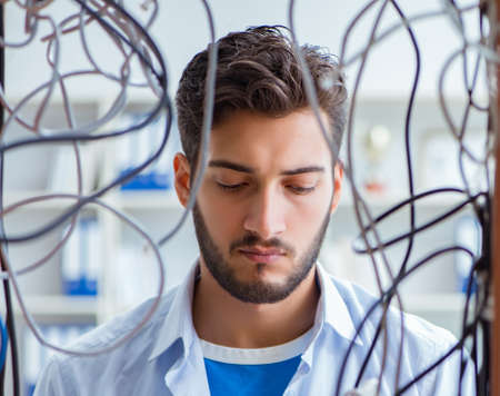 Electrician trying to untangle wires in repair conceptの写真素材