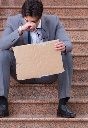 The desperate businessman begging on the streetの写真素材