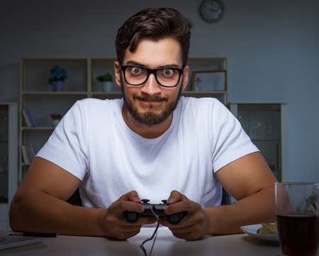 Young man playing games long hours late in the office