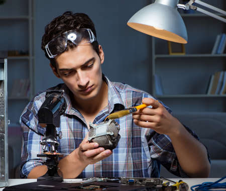 Computer repair man cleaning dust with brushの写真素材