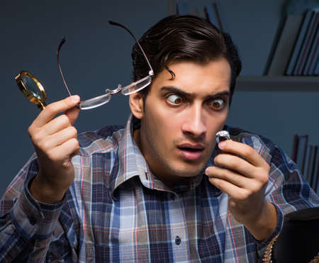 Young male jeweller working at night in his workshop