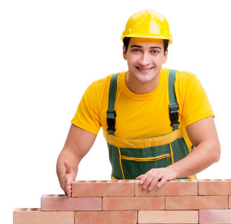 The handsome construction worker building brick wall