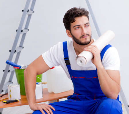 Repairman doing renovation repair in the house with paper wallpaの写真素材