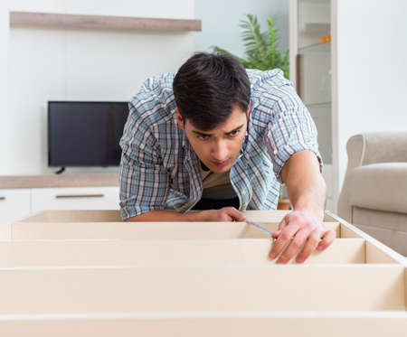 Man assembling furniture at homeの写真素材