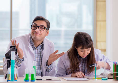 Two chemists working in lab experimentingの写真素材