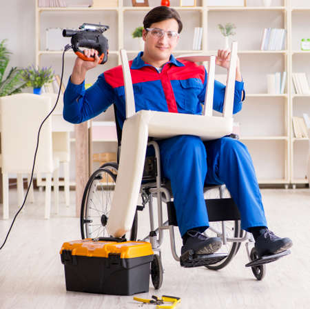 Disabled man repairing chair in workshopの写真素材