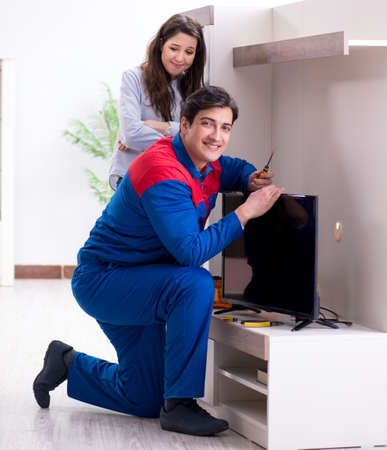 Tv repairman technician repairing tv at homeの写真素材