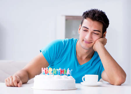 Young man celebrating birthday alone at homeの写真素材