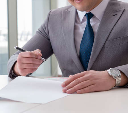 Businessman signing business documents in office
