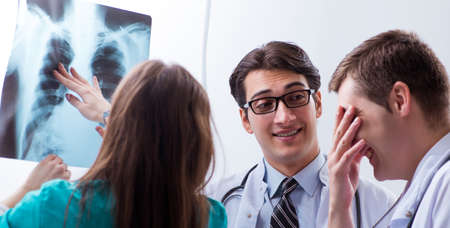 Three doctors discussing scan results of x-ray image