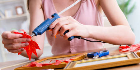 Woman decorating picture frame in scrapbooking conceptの写真素材