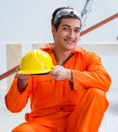 The carpenter wearing yellow hardhat in contractor workshop