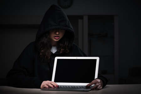 Female hacker hacking security firewall late in office