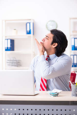 Young male employee suffering in the officeの写真素材