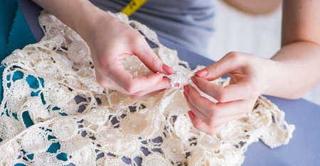 Woman tailor working on a clothing sewing stitching measuring fa