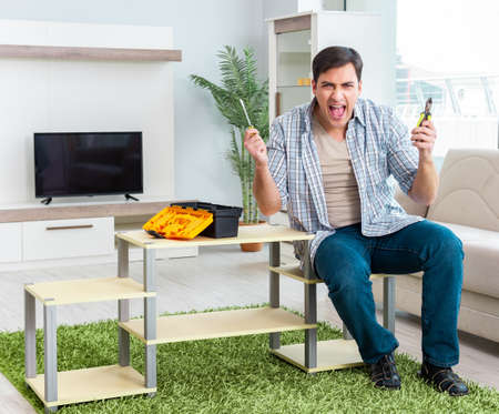 Man assembling furniture at homeの写真素材